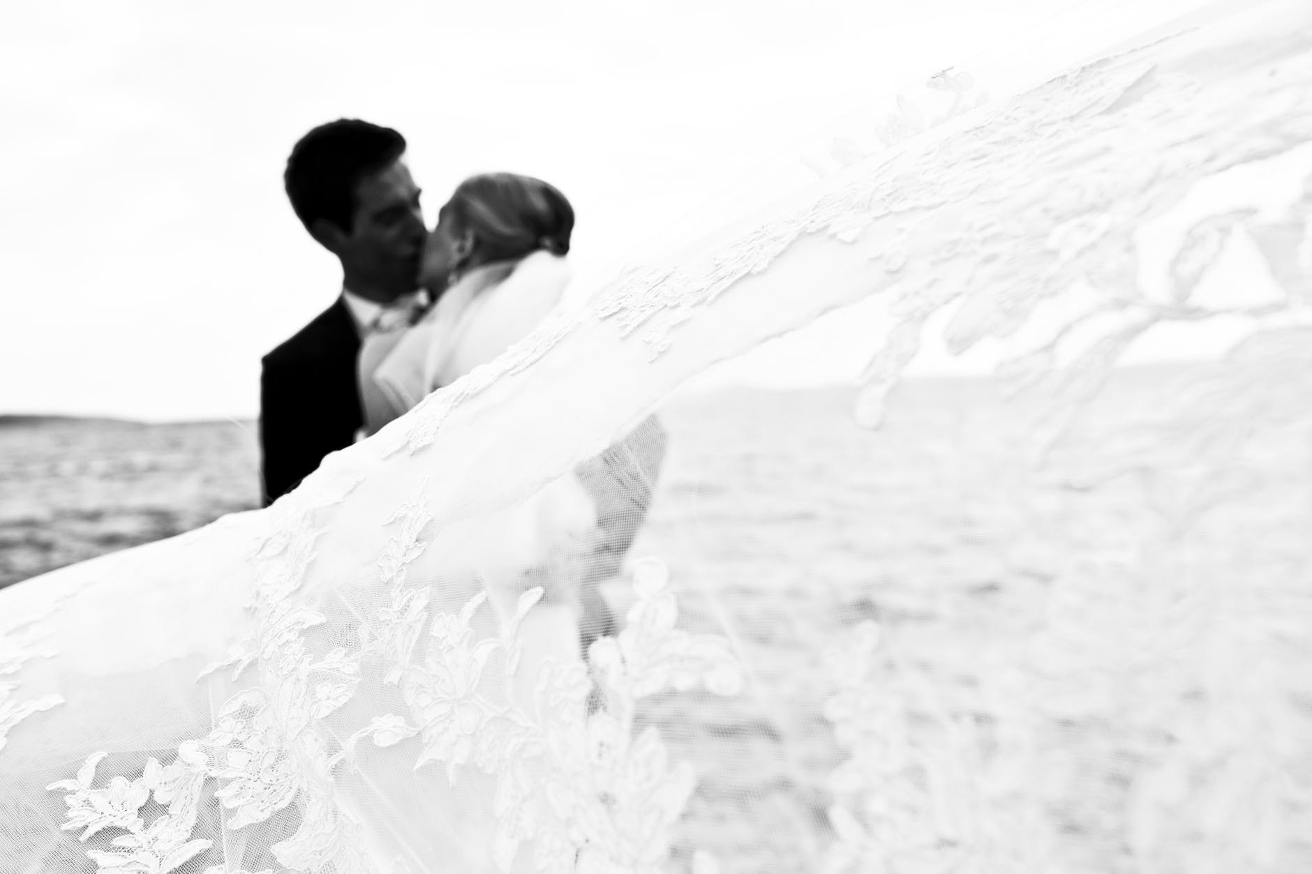 grayscale photography of kissing newly wed